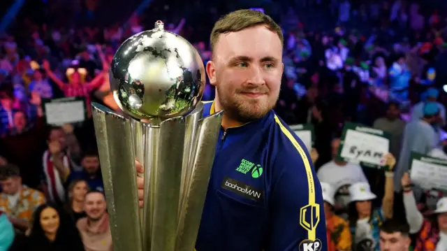 Luke Littler with the World Championship trophy