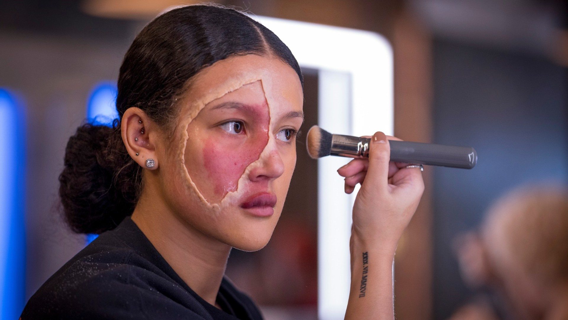 Ryley applying make-up around her birthmark