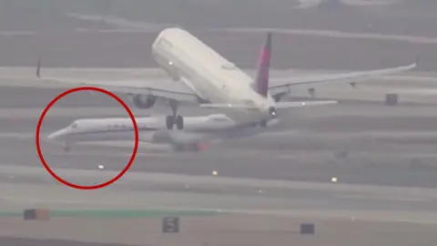 A jet is circled in red close to a commercial plane. 