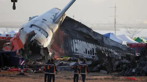 Reuters Firefighters take a look at the wreckage of the aircraft that crashed after it went off the runway, at Muan International Airport, in Muan, South Korea, December 31, 2024. REUTERS/Kim Hong-Ji