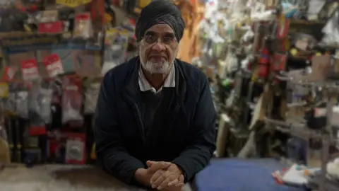 Hardware business owner Jagjit Singh Rayat in his shop. Items are on sale behind him.