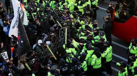 Reuters Anti-Yoon protesters clash with police officers as they march towards impeached South Korean President Yoon Suk Yeol's official residence