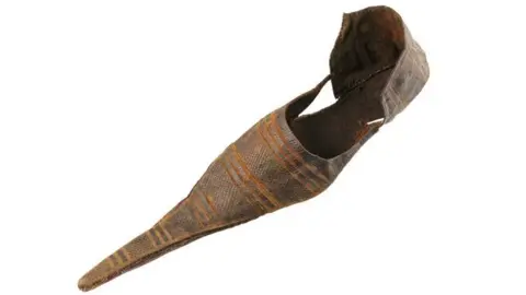 A long pointy poulaine shoe in brown leather