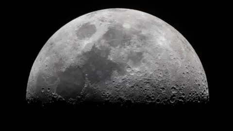 Close up image of the moon in black and white showing details of craters