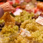 Una mujer escoge un ramillete de uva en el Mercado Central cuando dos de cada tres uvas consumidas procederán este fin de año de la DOP del Vinalopó (Alicante)