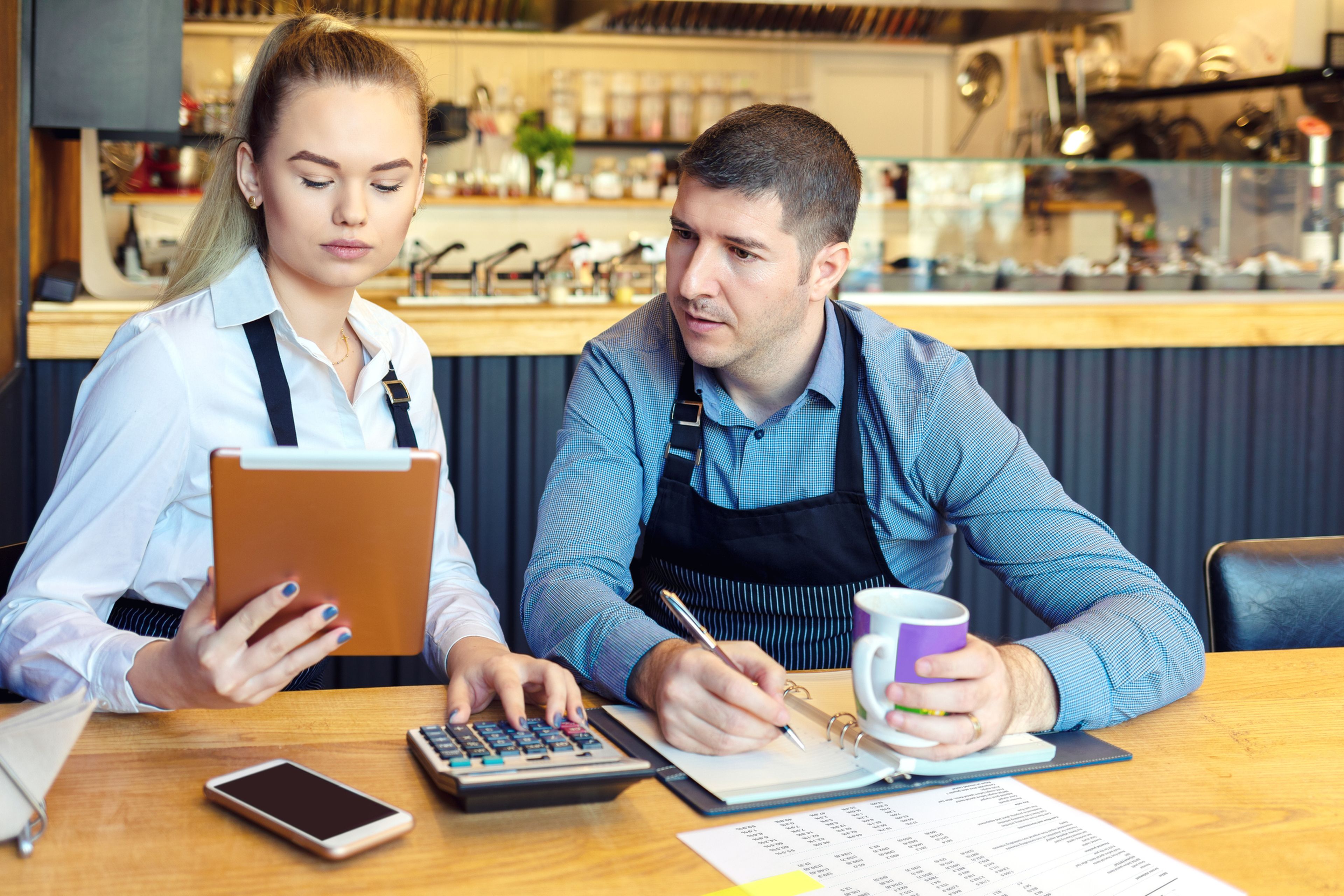 Trabajadores autónomos en restaurante, con calculadora