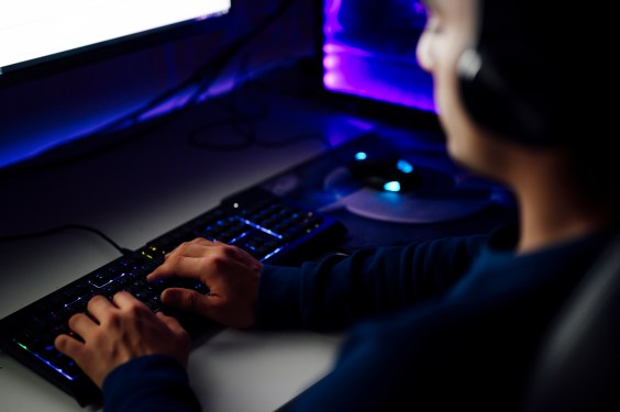 Image of a gamer playing a video game at a keyboard.