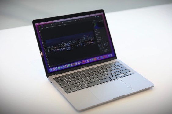 A MacBook laptop on a white desk.