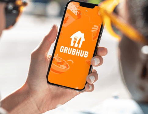 Grubhub app/logo displayed on a smartphone phone held in hand