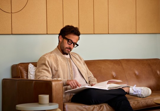 man sitting on couch, reading