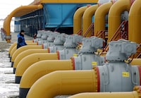 FILE PHOTO: A gas worker walks between pipes in a compressor and distribution station of the Urengoy-Pomary-Uzhgorod gas pipeline, some 30 km (19 miles) from the south western Russian city of Kursk January 4, 2006. REUTERS/Sergei Karpukhin//File Photo