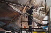 A worker uses an angle grinder on a vessel under construction at Seaspan Shipyards, in North Vancouver, B.C., on Thursday, October 10, 2024. THE CANADIAN PRESS/Darryl Dyck