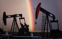 A rainbow appears to come down on pumpjacks drawing out oil and gas from wells near Calgary, Alta., Monday, Sept. 18, 2023.