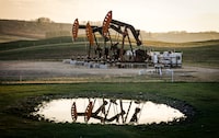 FILE - Pumpjacks draw out oil and gas from well heads as wildfire smoke hangs in the air near Calgary, Alberta, May 12, 2024. (Jeff McIntosh/The Canadian Press via AP, File)