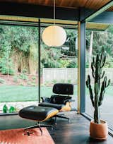 In true mid-century fashion, a George Nelson Bubble Lamp is paired with an Eames Lounge by Charles and Ray Eames in a corner of the living room. The glass walls and mitered corner are original features of architect Saul Zaik’s 1956 design.