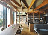 In the open living and dining room of a hillside family home in Japan, Eames shell chairs surround a custom walnut table by Kagura. The upholstered seating is by Arflex. The architect, Masahiro Harada of Mount Fuji Architects Studio, also designed the custom kitchen island and stove vent.