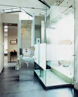 The dramatic bathroom features a glass sink and vanity designed and cast by Mies Grybaitis of OIA. The etched glass shower is accented by green glass tile.