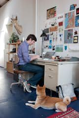 A familiar scene in the Benoit home: Peter paints at the Steelcase desk—"I do all my work here," he says—while Ando sits nearby, waiting for attention.