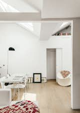 The living area is furnished with a marble table that Molineus designed, ringed with Series 7 chairs by Arne Jacobsen for Fritz Hansen and bookended by a Mezzaluna Terra floor lamp by Bruno Gecchelin and a Spun chair by Thomas Heatherwick for Magis.