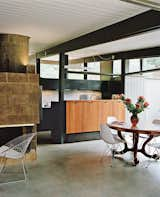 The duo added custom redwood cabinetry on the dining area side. The pendants are from Birchwood Lighting.