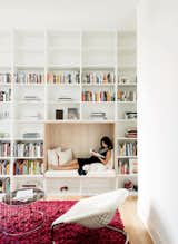 On one side of the house, a white central staircase leads to a split-level landing the Robertsons call "the reading room." "We needed a place to hang out and for the kids to read," explains owner Vivi Nguyen-Robertson. Awaiting the birth of the couple's son, she relaxes in a built-in reading nook in the library.