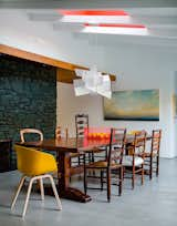 Walnut panels and touches of bright red warm up the minimalist space, which the owners wanted to be “clean, eclectic, and modern.” The pendant is Big Bang by Foscarini.