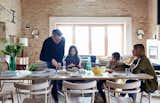 The family gathers at an early prototype of the Achilles table from the Pinch collection. Surrounding it are chairs that were designed by Russell and produced by Ercol for London’s Holland Park School. The couple built the doors and windows themselves.