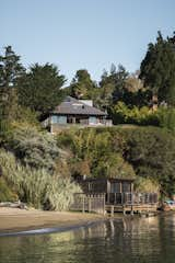 Built with a heavy timber post-and-beam structure, this renovated Tiburon kit house retains its standard footprint, framing, and tiled roof. Massive sliding glass doors were added to create an indoor/outdoor living experience.  