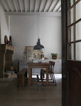 The formal dining room, accessible from the kitchen through a set of walnut doors, features an original stone fireplace that dates to the 13th century.