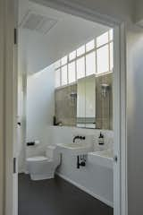 The newly remodeled bathroom features a sleek black-and-white color palette, with Duravit wall-mounted sinks basking in the filtered light of clerestory windows.