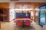 The home features beautifully restored wood paneling, and it’s filled with unique midcentury furniture. Here, a retro dining set complements the geometric elements found throughout the interior.