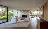 In the living room, an original natural rock fireplace continues through the glass to divide the patio.