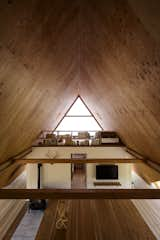 The view from the opposite end, where an additional loft area is used as the children’s bedroom. Plywood ceilings complement the hardwood floors below.