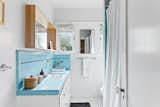 Original blue tile lines the counter and backsplash in one of the two bathrooms.