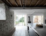 Painted wood and steel beams subtly mark a separation between the former cattle shed and ruin footprint. The two areas now seamlessly flow together as a kitchen, dining, and living area.