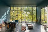 A sofa by Stephen Kenn Studio joins ceramic tables by artist Ben Medansky in the glass-walled living area. The AIM pendants are by Ronan and Erwan Bouroullec for Flos and the Oda floor lamps are from Pulpo. The metal artworks are by Guy.