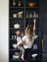 Erin holds the couple’s son in front of pantry shelving by Fischer Custom Cabinets.