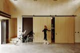 On a side wall, sleek barn doors open to reveal a storage area for bikes. Stairs near the garage entrance, which features a door from Renlita, lead to a vaulted loft that was originally intended as an exercise room but is now used by Rakesh as an office.