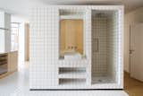 For the redesign of a 430-square-foot flat built in the 1970s, Madrid firm BURR Studio integrated all the main facilities of the home into a central core. “The toilet is the only element that can be isolated,” notes the firm. “The rest of the areas merge into one another so that the tenants essentially sleep in the bathroom, as well as shower in the living room.”