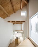 Two balconies are tucked beneath the vaulted roofline in the double-height kitchen/living room.