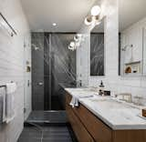 Barker mixed inexpensive subway tiles with an expensive marble slab in the master bathroom. The mix of high and low pieces defines the style of this home.