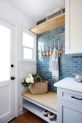 Rejuvenation wall hooks match the shade of the bench cushion. The laundry room's Heath tiles are colored in "Heron Blue."