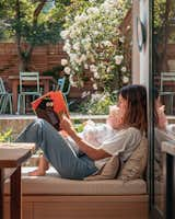 The owner, a school teacher, reads with her child on the banquette, which is bathed in rare London sun.