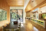 The dining table area sits at the meeting point between the two wings, with the Douglas fir ceiling spilling downward to form an entire wall (showcasing a painting by Zhou Hongbin).