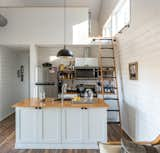 The mezzanine above the open-plan kitchen is a loft bedroom with a set of twin beds, where guests can sleep.