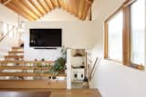 A timber staircase accesses the loft-like office and is wider at the bottom, where it doubles as shelving.