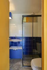 Cobalt blue wall tile brightens the bathroom and contributes to the home’s palette, which juxtaposes earth tones with primary colors.