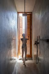 Louver doors in the shower provide privacy while allowing strips of light to filter in.