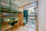 The two second-level bedrooms are separated by a sliding wood door that sections the children's room from the parents' room. A small glass staircase in the parents' room ascends to a balcony and helps flood the space with natural light.