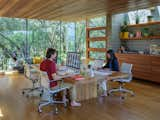 Sharon and Mike Matas work at large wood table in the studio while their daughter plays.